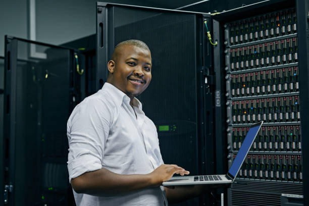 Shot of an IT technician using a laptop while working in a data center